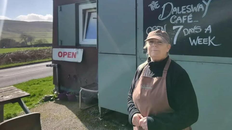 Cafe owner Kate Bailey stands next to her cafe which is a snack van at the side of the A59 