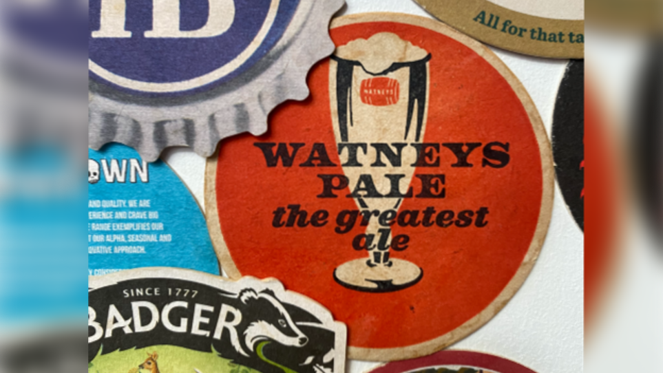 A red beer mat depicting a glass filled with ale, with the following text on it- Watneys Pale the greatest ale 