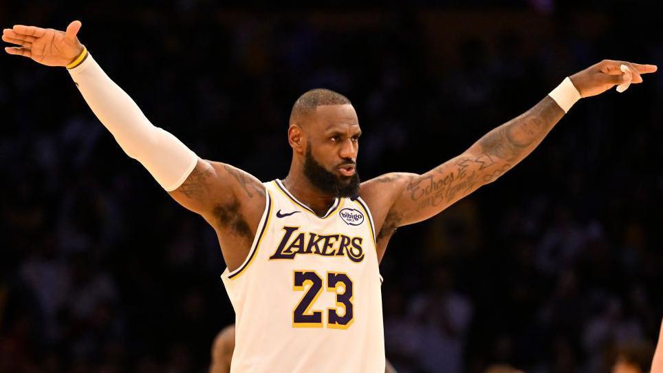 LeBron James lifts his arms and acknowledges the crowd