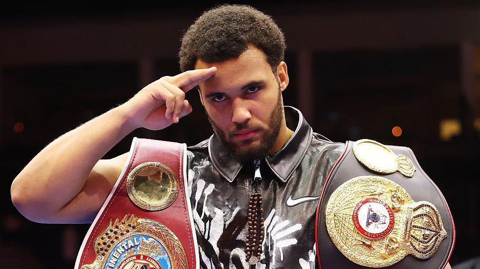 Moses Itauma salutes the cameras holding his belts