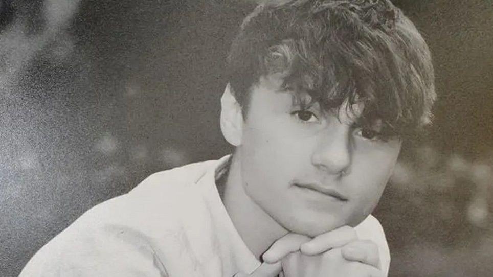 A black and white photo of Joshua Reeson looking at the camera. He has brown hair and is wearing a white shirt.