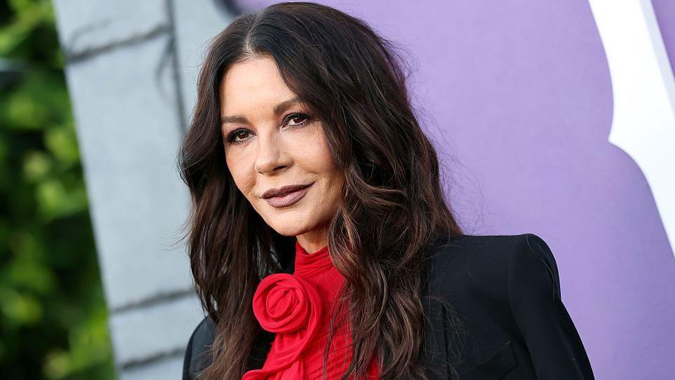 Catherine Zeta Jones in a red dress and black jacket