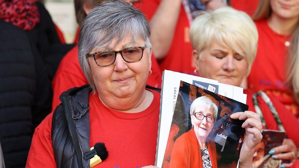 Brenda Doherty of Northern Ireland Covid-19 Bereaved Families for Justice holds a photo of her late mother Ruth Burke