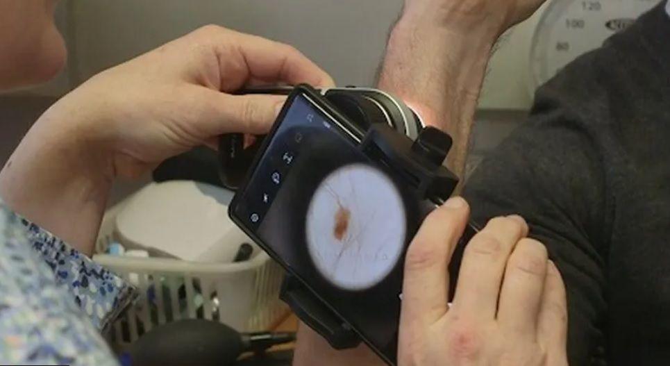 Hand holding a circular piece of equipment with a dial on the front