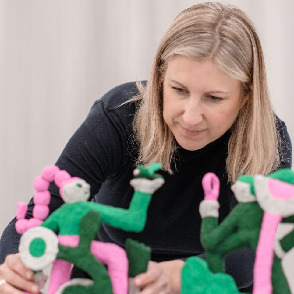 Creative director Stacey Hunter looking at models of people at one of the festival's exhibits