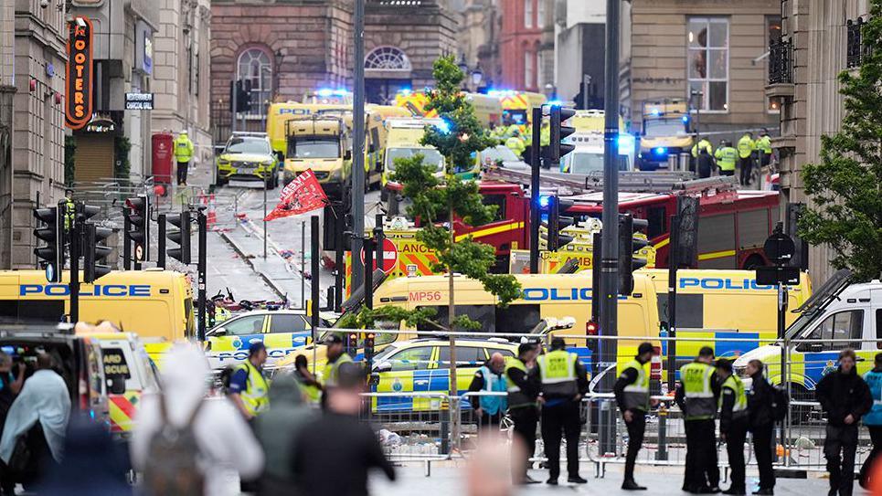 Dozens of emergency vehicles on Water Street, Liverpool, behind a police cordon after a car ploughed into a crowd of football fans.