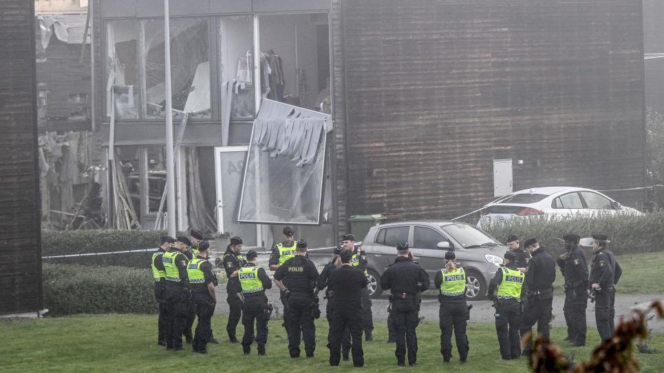 Policemen stand in front of a damaged building after a powerful explosion occurred in the early morning of September 28, 2023 in a housing area in Storvreta outside Uppsala, Sweden. 