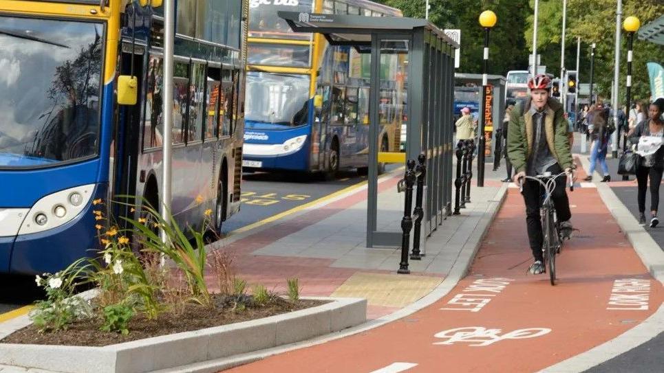 A person on a bike using a cycle path in Manchester City Centre