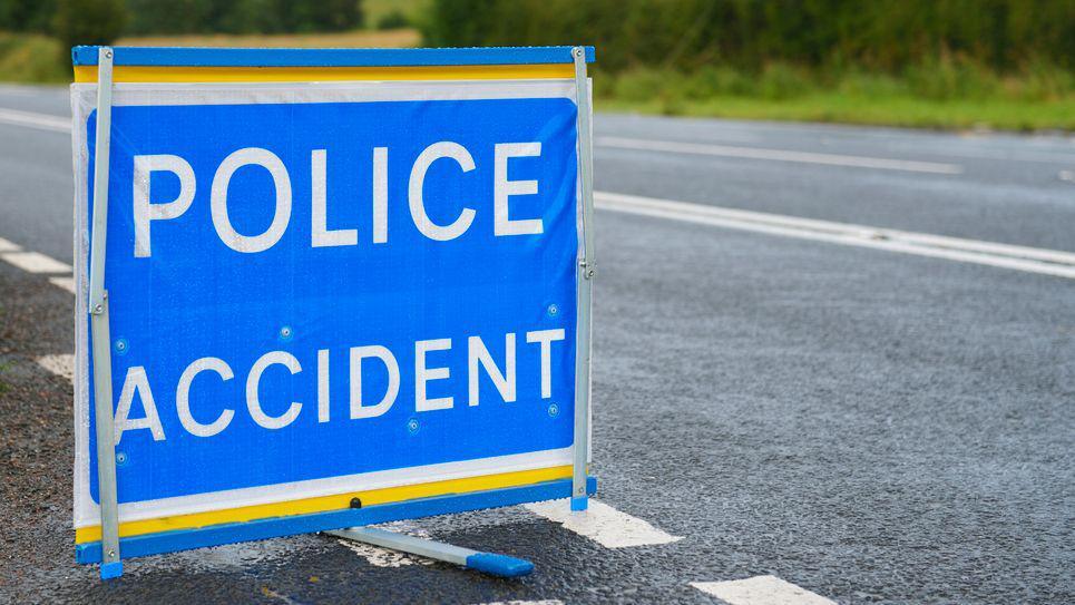 A police accident sign, bold white letters on a blue sign.

