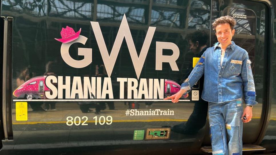 Image of Nick Grimshaw next to a green GWR train with Shania Train branding