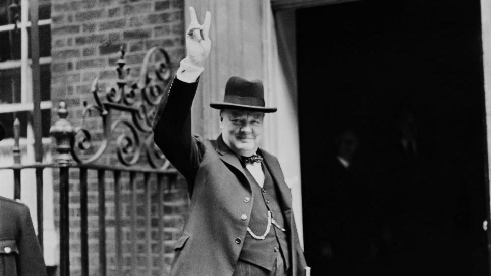 Prime Minister Winston Churchill outside 10 Downing Street holding up the famous 'V for Victory' hand signal.