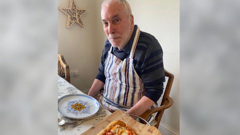 A man sitting having some pizza 