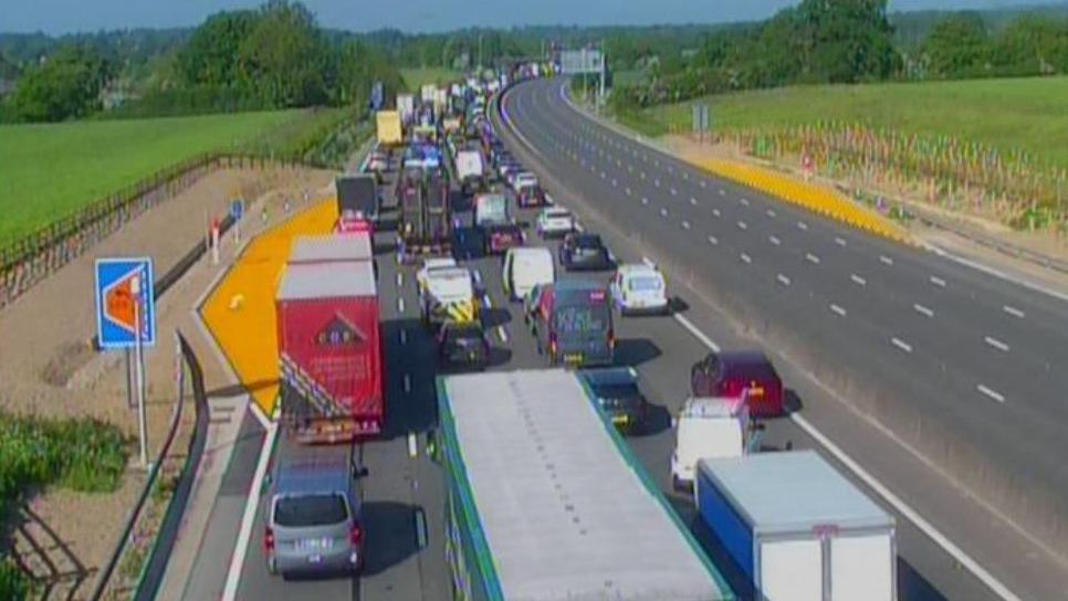 A motorway, showing one carriageway full of moving traffic, while the lefthand carriageway is completely empty