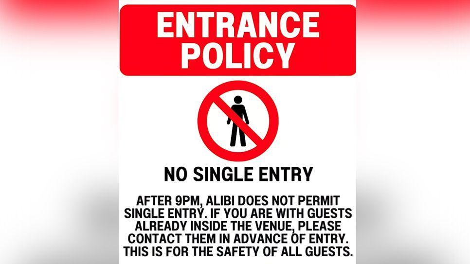 Red white and black sign designed like a road sign saying no single entry into the Alibi venue.