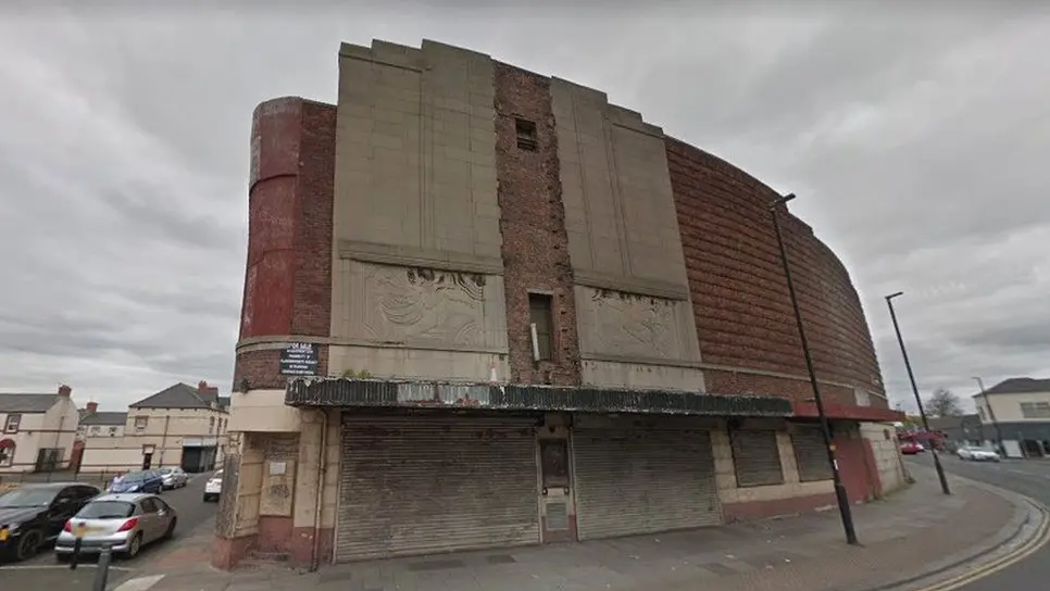 Disused shabby looking curved brick building with closed up windows