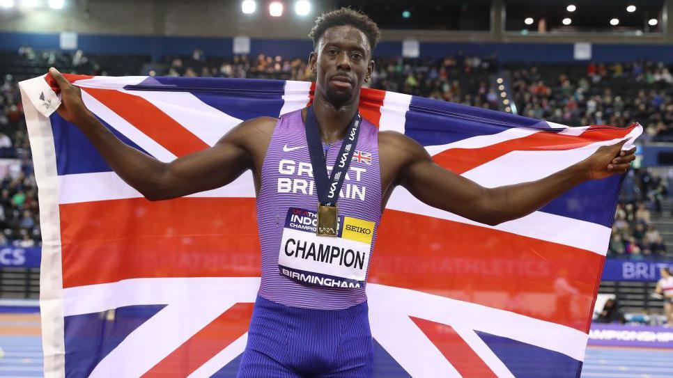 Reece Prescod with a union flag after winning gold in the 60 metres at the 2023 British Indoor Athletics Championships
