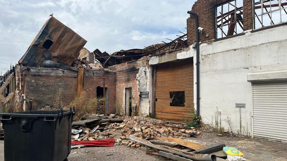 The aftermath of the Baldock fire a year after the blaze, showing burnt-out units and a collapsed roof