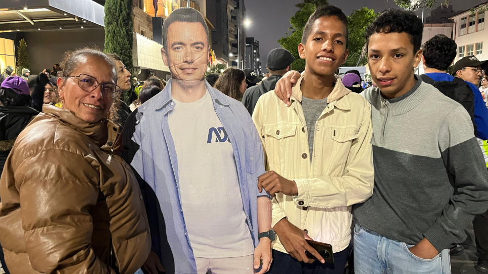 Ecuadorean supporters of Daniel Noboa stand next to a cardboard cut-out of the president