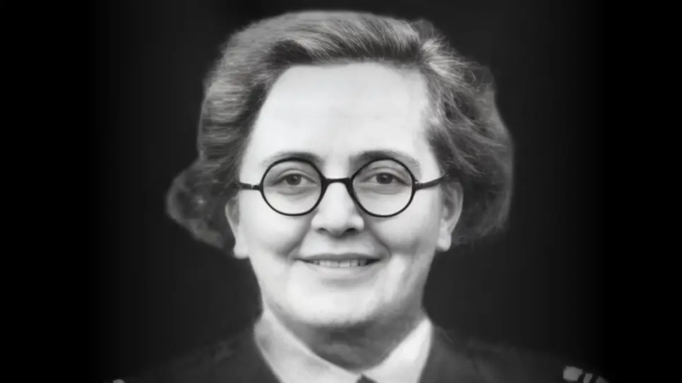Flight Captain Susan Slade in black and white. She has short, combed back hair, round dark glasses and is slightly smiling. The collar of her shirt and jacket can be seen.