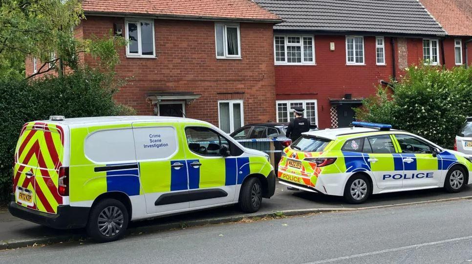 Police van and a police car are parked outside a property