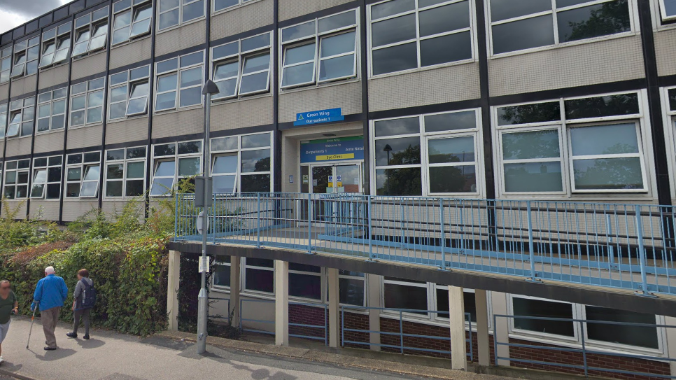 The entrance to Crawley Hospital - a grey building with a blue door