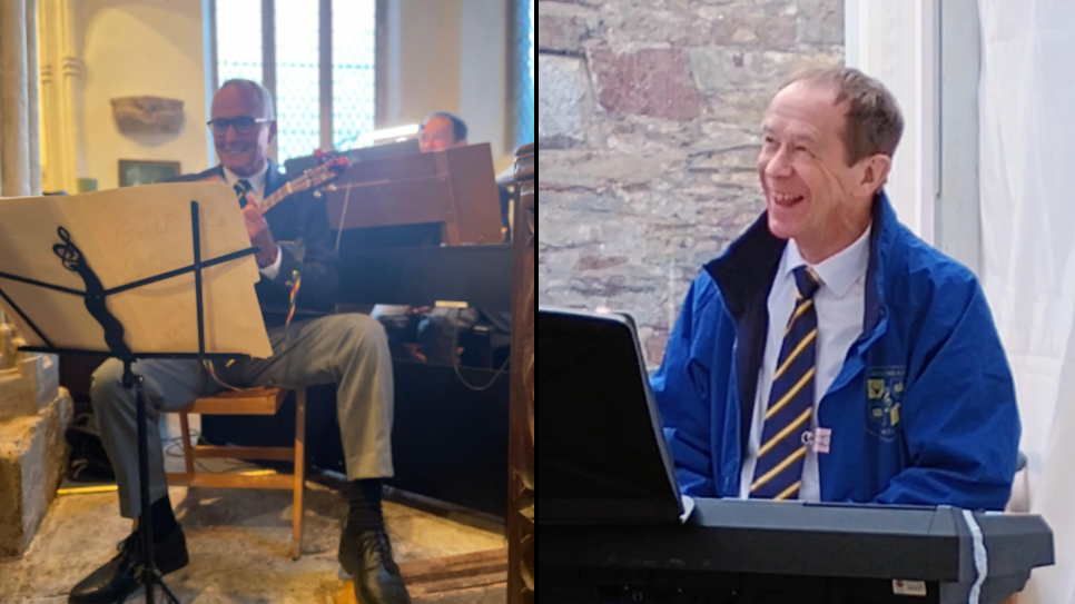 The picture is split in two. On the left is Bill Spill sat in a chair playing ukelele. He's smiling while looking at sheet music, wearing a shirt and tie and suit jacket with grey trousers. He appears to be in a church-like building. On the right is Alan Hemsley who is playing keyboard. He is looking to the left and smiling. He is wearing a shirt and tie and a blue coat. He is back by a grey brick wall.