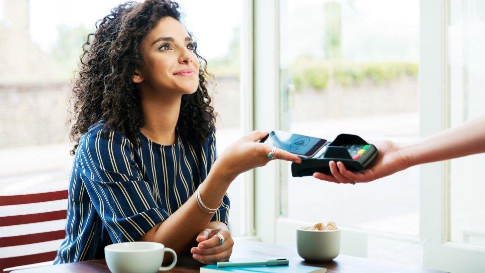 Woman pays for coffee in a cafe