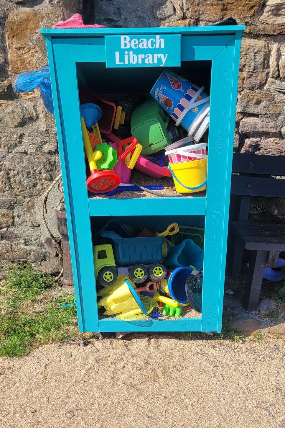 Beach library - toys in a bookshelf at a beach