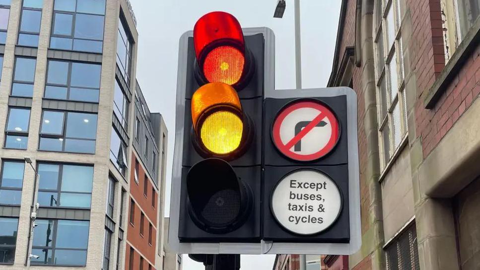 A close-up of a set of traffic lights in Preston. The red and amber lights are illuminated.