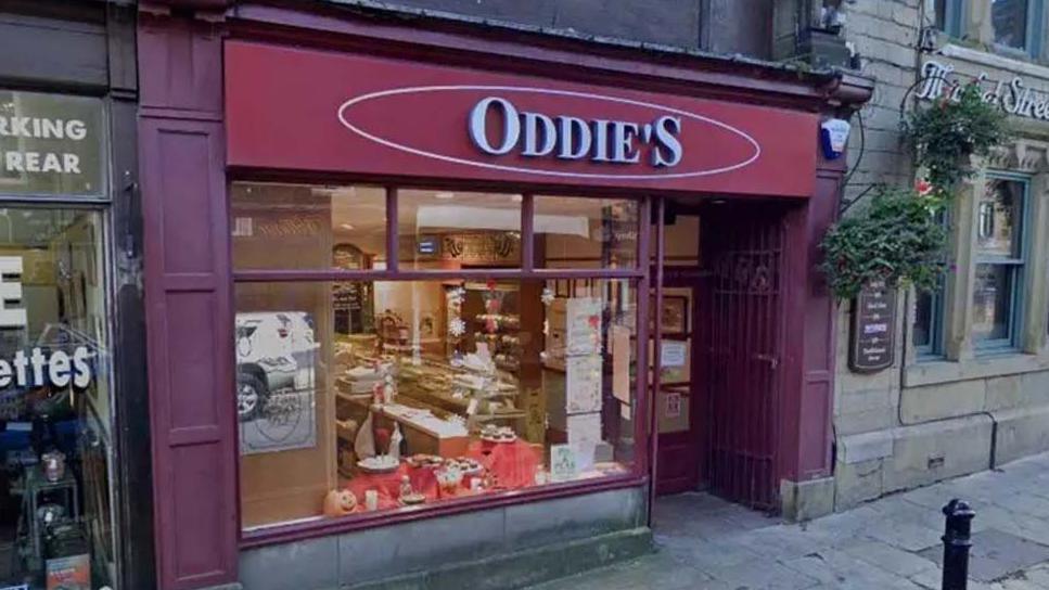 Street view of the red shop front of an Oddie's bakery in Colne