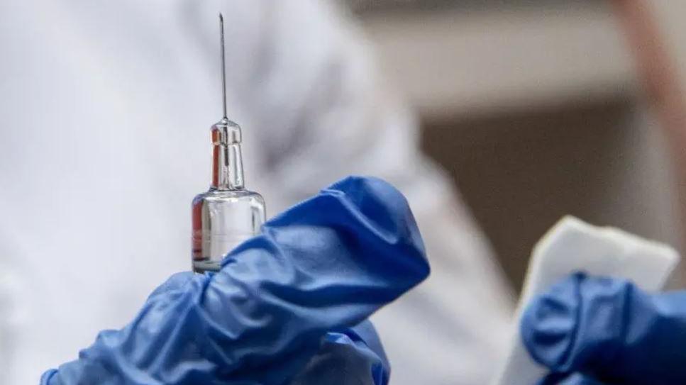 A needle in the hands of a medic, with blue gloves in shot.