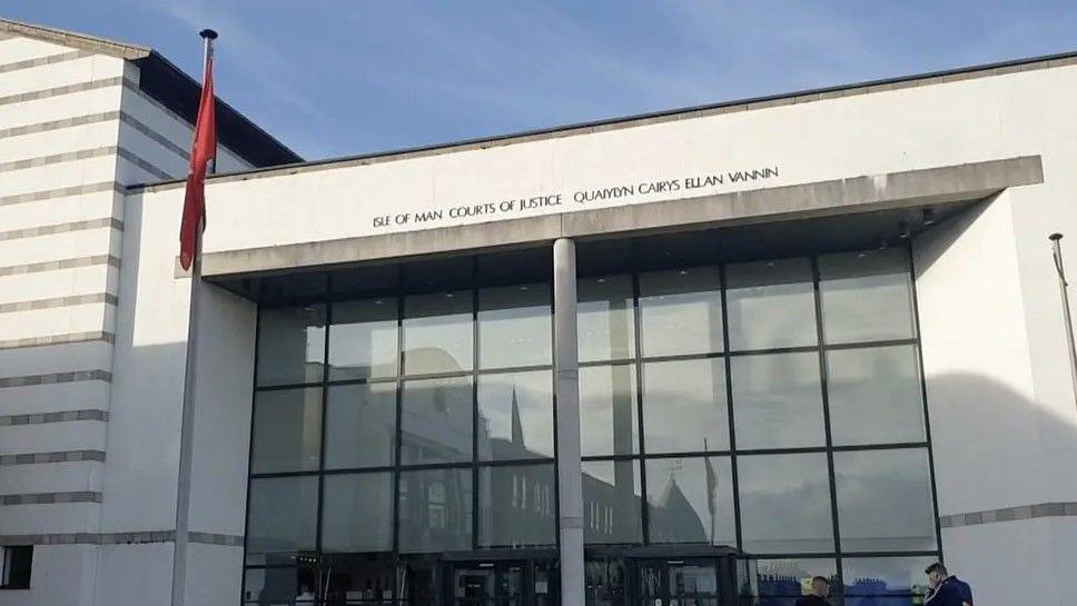 The outside of Douglas Courthouse, which is a white and glass-fronted building and has Isle of Man Courts of Justice in English and Manx above the entrance.