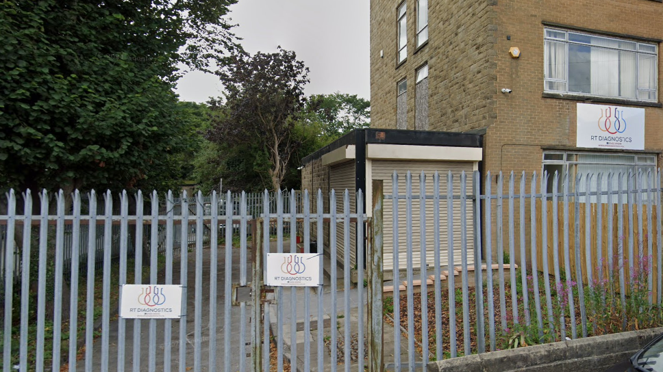 A large office-type building with a sharp-pointed metal fence around the front.