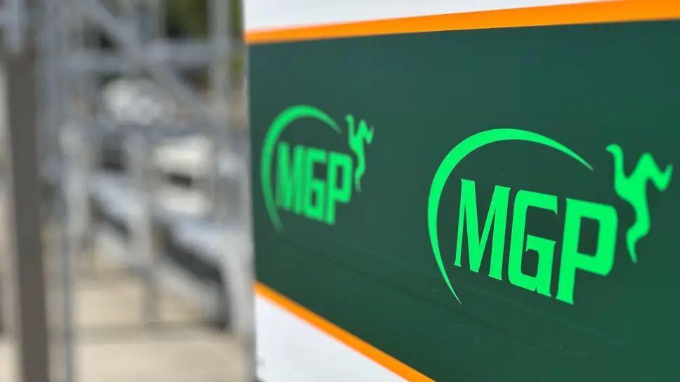 A dark green sign in pit lane, bearing the MGP logo.