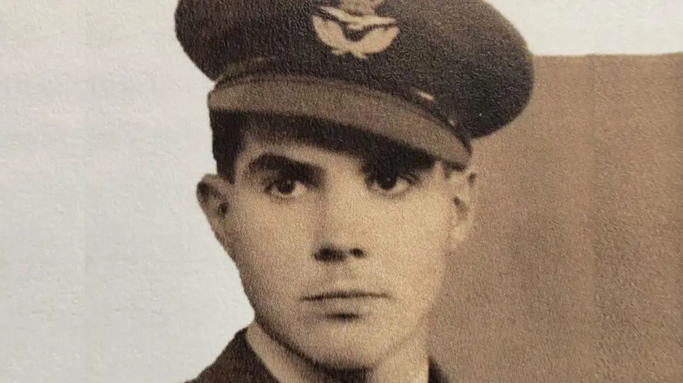 An old sepia colour photo of a young Stanley Booker in his RAF uniform. His peaked cap is at a slight angle and bears the RAF emblem.