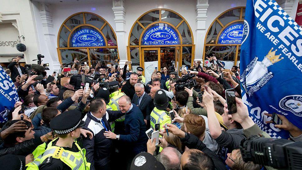 Claudio Ranieri is mobbed by fans on his way out of an Italian restaurant