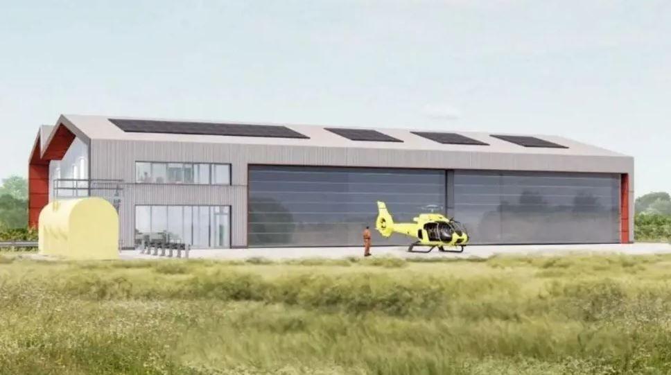 An artist's impression of the new Yorkshire Air Ambulance base shows a large rectangular building with solar panels and large glass shutters. In front of the building is a man wearing orange and a yellow helicopter.
