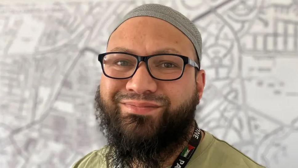 Councillor Mothin Ali wears glasses and a head covering.