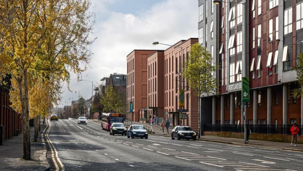 An artist's impression of the new apartments at the site of Havelock House. There are trees on the left of the road and a brown apartment building and a grey office block on the right. Cars and a bus travel down the road. 