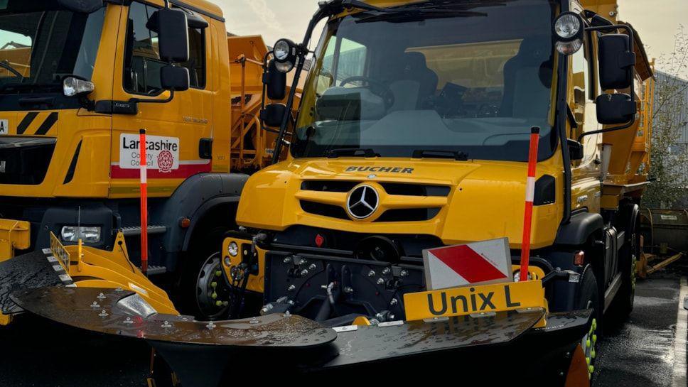 A gritting vehicle. It's large, yellow, and has machinery/tools on the front.