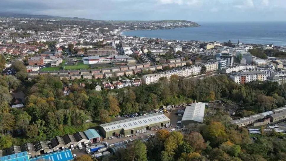 An aerial view of buildings in Douglas with the arching coastline.