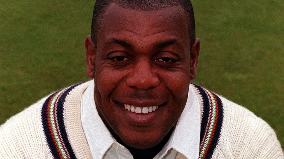 David 'Syd' Lawrence smiling at the camera wearing a thick cricket jumper