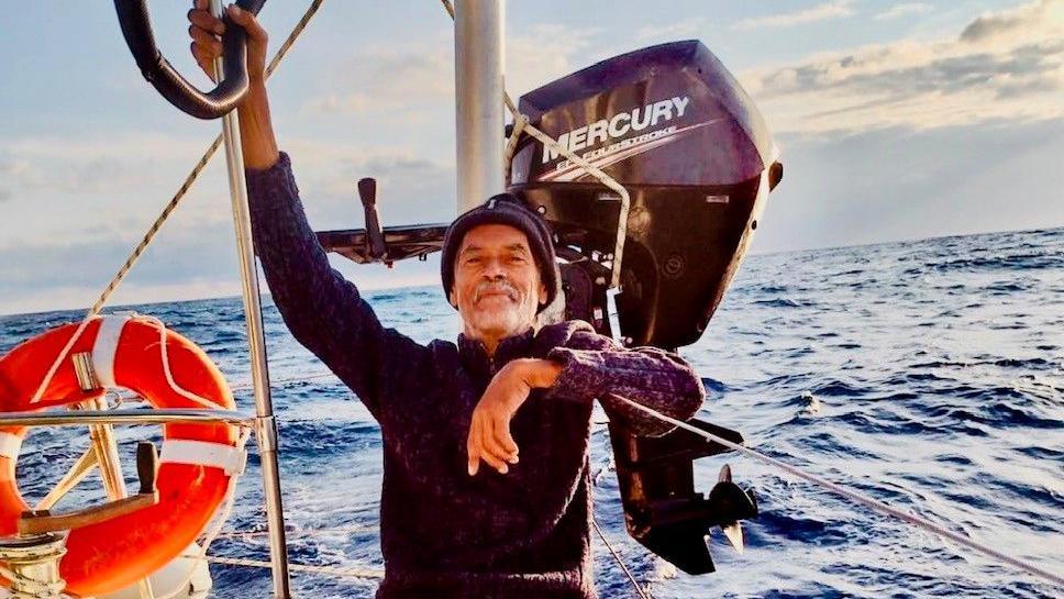 Charles Todd clutches onto his yacht as someone takes a photo of him out at sea