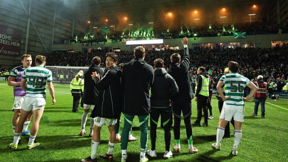 Celtic players watch on as their fans celebrate their last-gasp winner