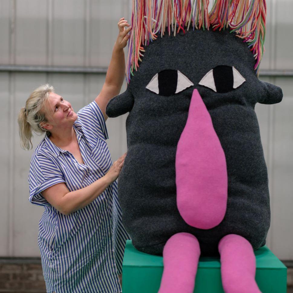 A staff member at Dundee Design Festival with a creature made from fabric