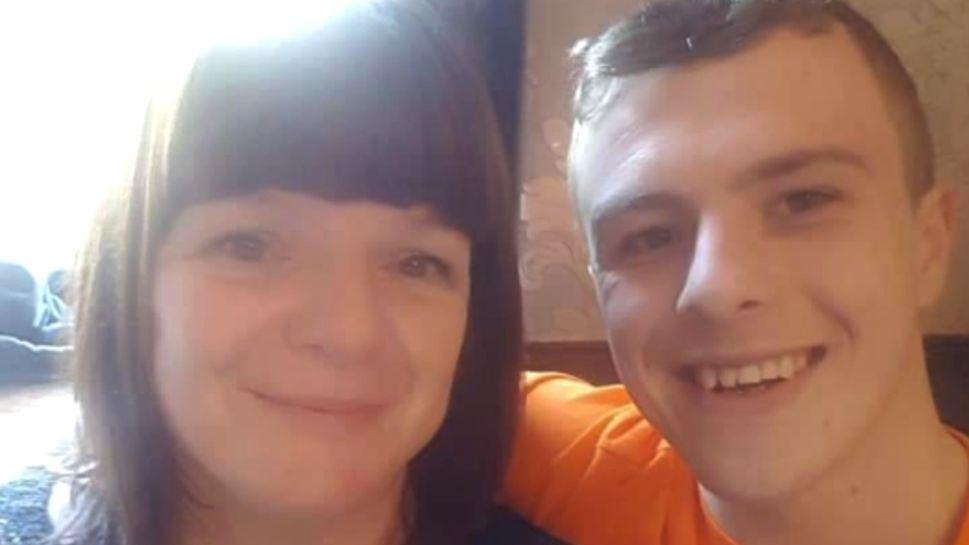 A selfie of Ms Allwood with her son Jack. She is on the left, with shoulder length brown hair and a block fringe. Jack is on the right, wearing an orange t-shirt and sitting with his arm around his mum. They are both smiling at the camera.