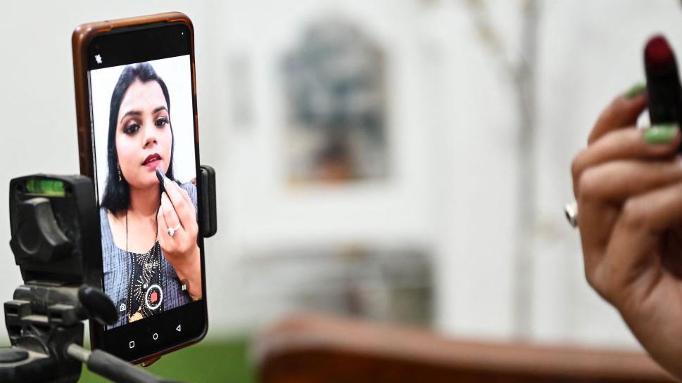 An Indian social media make-up influencer pictured on her mobile screen, making tutorial videos in Bulandshahr, Uttar Pradesh. 