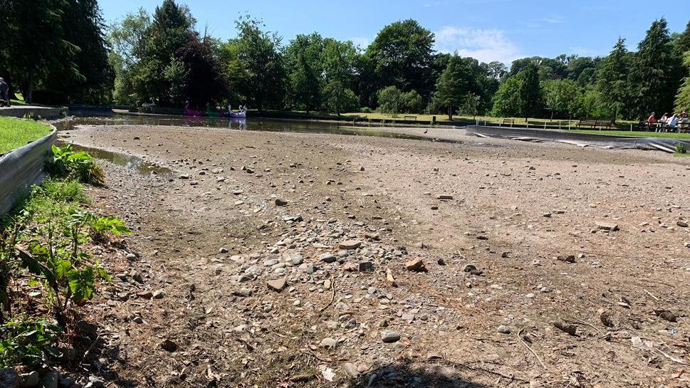 A large expanse of rubble across where there was once a boating pond