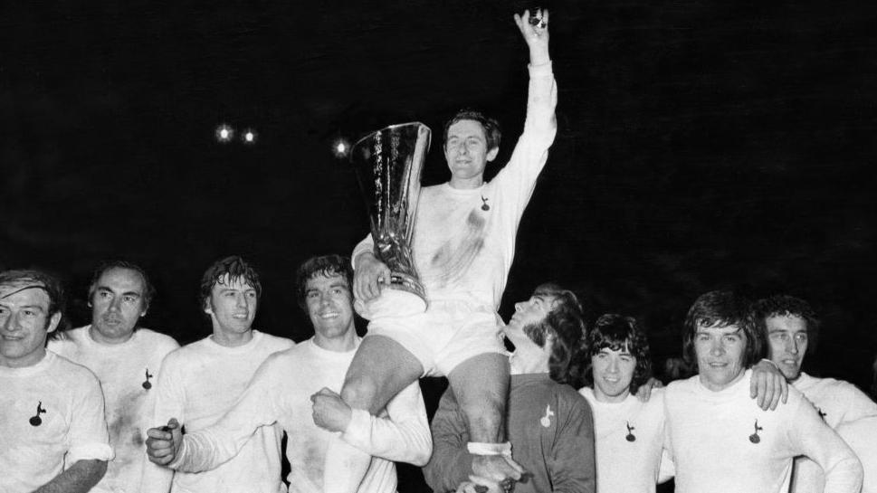 Spurs captain Alan Mullery sits on the shoulders of his team-mates as he proudly holds aloft the UEFA Cup trophy on a lap of honour after the match, 17th May 1972. 