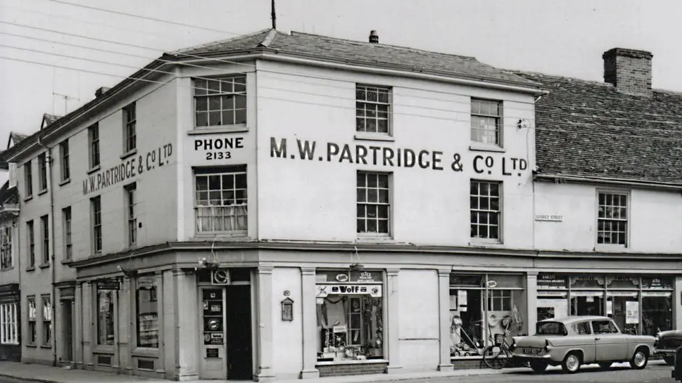 A black and white photo of a building in High Street, Hadleigh, featuring the words M.W Partridge & Co. Ltd.